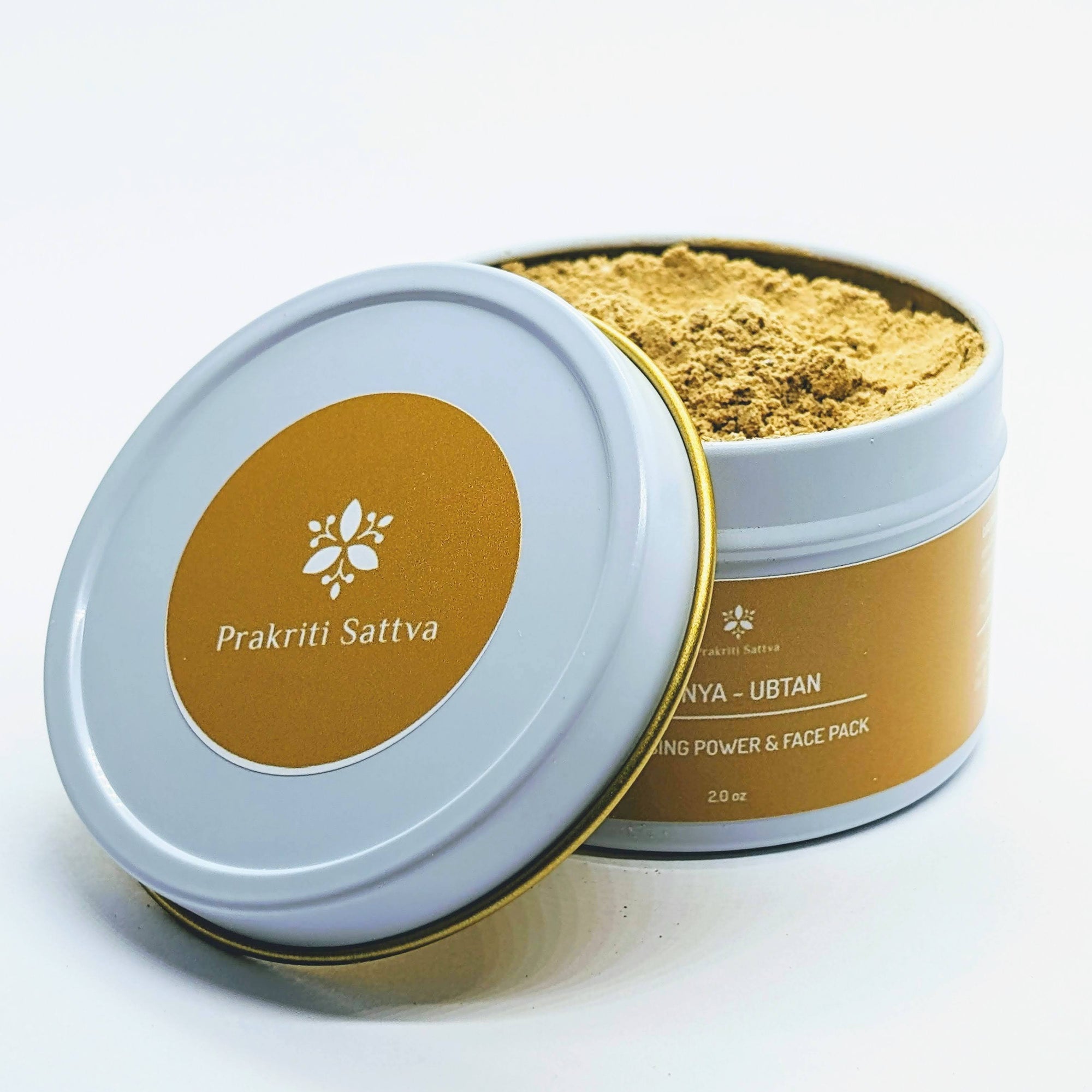 Prakriti Sattva Ayurvedic Ubtan Powder. A jar of orange-hued powder, perfect for natural face and body cleansing and scrubbing. The label features Ayurvedic herb powders like mung bean flour, besan / chickpea flour, rice flour, neem, licorice, rose, indicating the natural ingredients used.