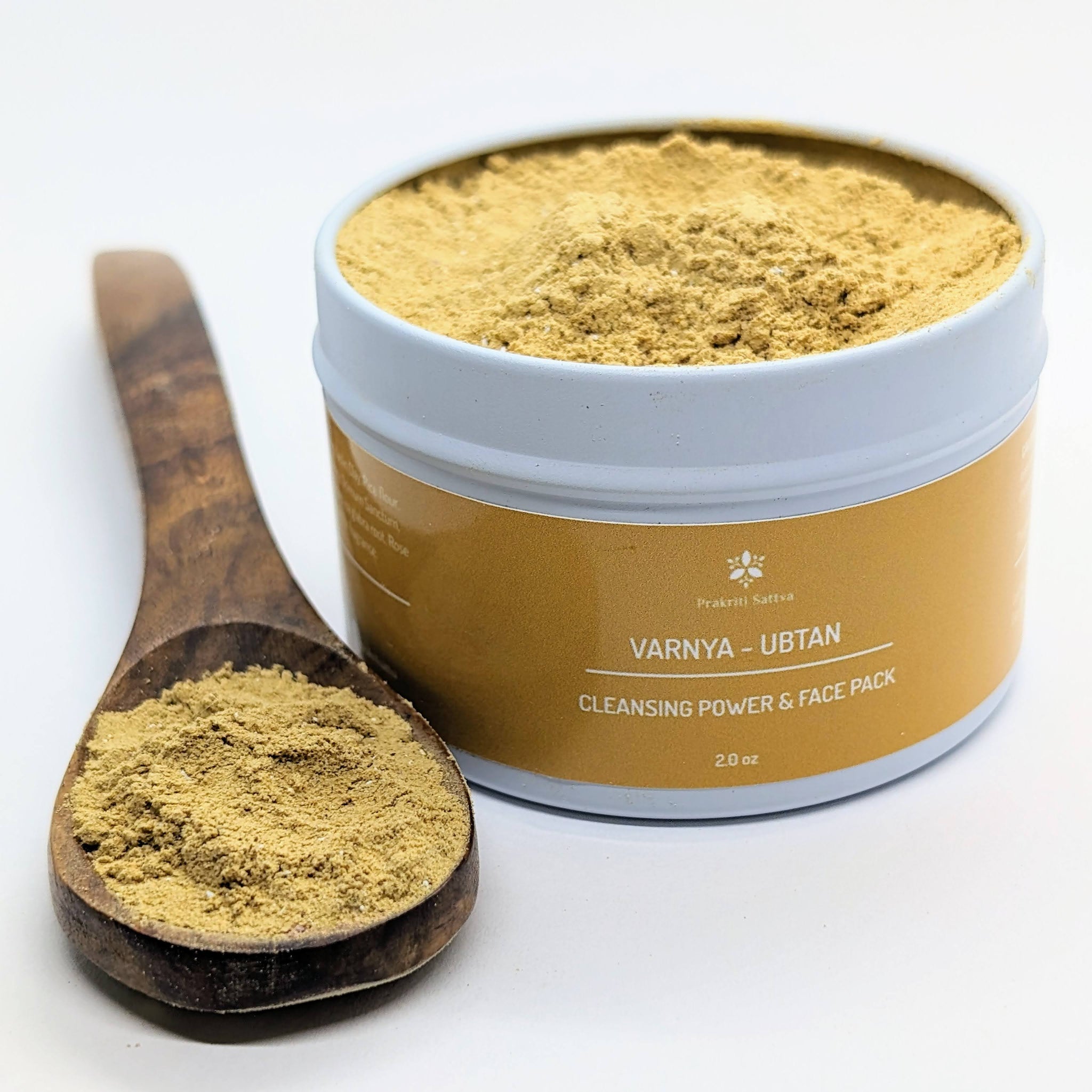 Prakriti Sattva Ayurvedic Ubtan Powder. A jar of orange-hued powder, perfect for natural face and body cleansing and scrubbing. The label features Ayurvedic herb powders like mung bean flour, besan / chickpea flour, rice flour, neem, licorice, rose, indicating the natural ingredients used. Nalangu maavu