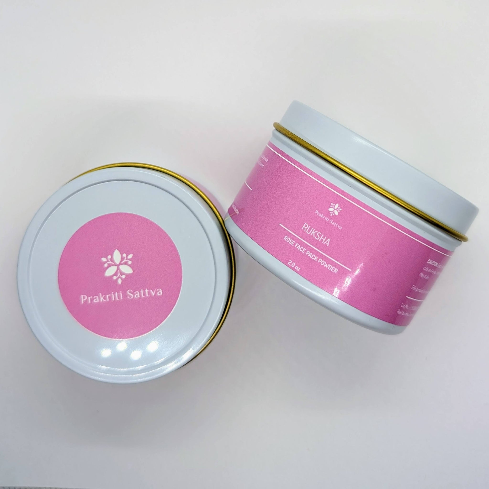 Ayurvedic Natural Rose Face mask , rose face pack. Two jars of two ounce rose face pack are laid side by side. Ayurvedic Natural Rose Face mask , rose face pack. Ayurvedic Natural Rose Face mask , rose face pack. A jar of pink-hued face pack powder, perfect for natural skin care. The label features Ayurvedic symbols and herbs, including rose, colloidal oatmeal, French pink clay, hibiscus petals, licorice root, coconut milk, aloe vera, and essential oils, indicating the natural ingredients used.