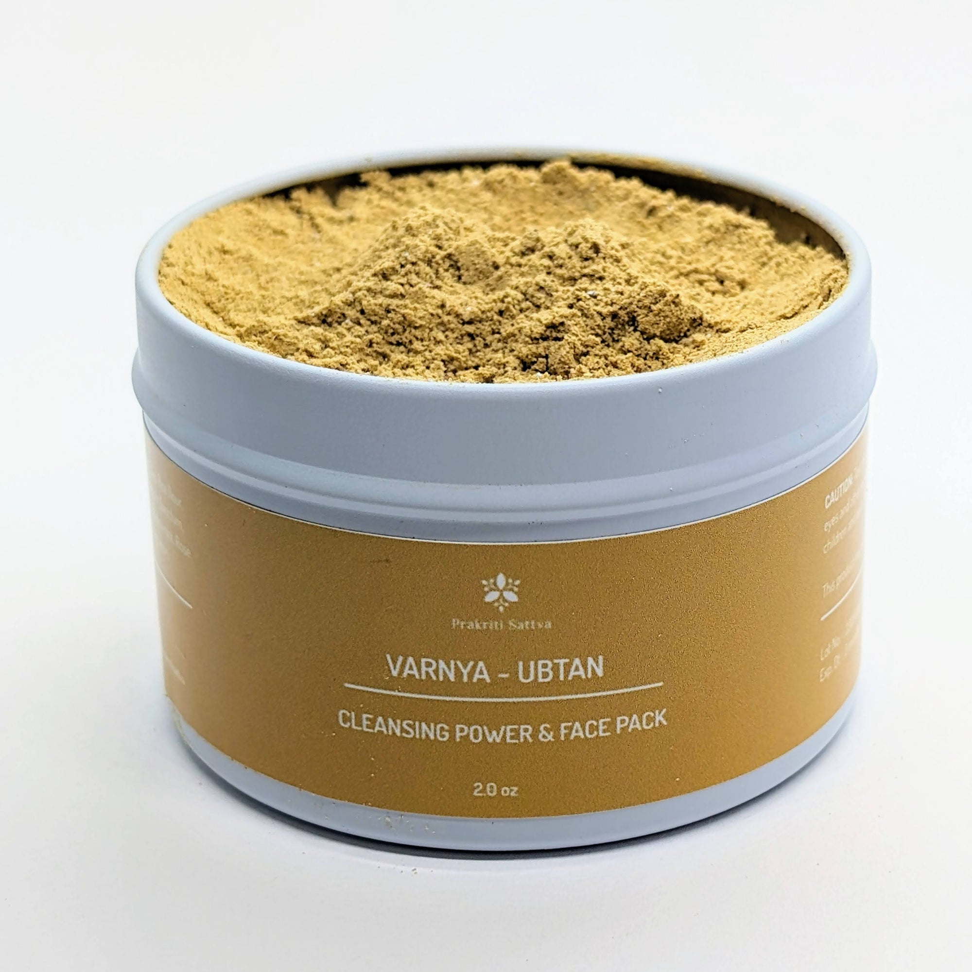 Prakriti Sattva Ayurvedic Ubtan Powder. A jar of orange-hued powder, perfect for natural face and body cleansing and scrubbing. The label features Ayurvedic herb powders like mung bean flour, besan / chickpea flour, rice flour, neem, licorice, rose, indicating the natural ingredients used.