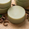 Prakriti Sattva botanical hair care products including shampoo bars and a bottle on a wooden surface.