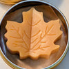 Tin jar of 1 ounce Prakriti Sattva Paduka Lotion bar balm for cracked heels and dry hands in a leaf shape.