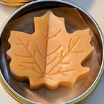 Tin jar of 1 ounce Prakriti Sattva Paduka Lotion bar balm for cracked heels and dry hands in a leaf shape.