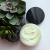 A four ounce jar of Prakriti Sattva Natural Deep Conditioning Hair Mask. The jar is filled with a creamy, green product. The black lid is on the side and there is a succulent plant on the side.