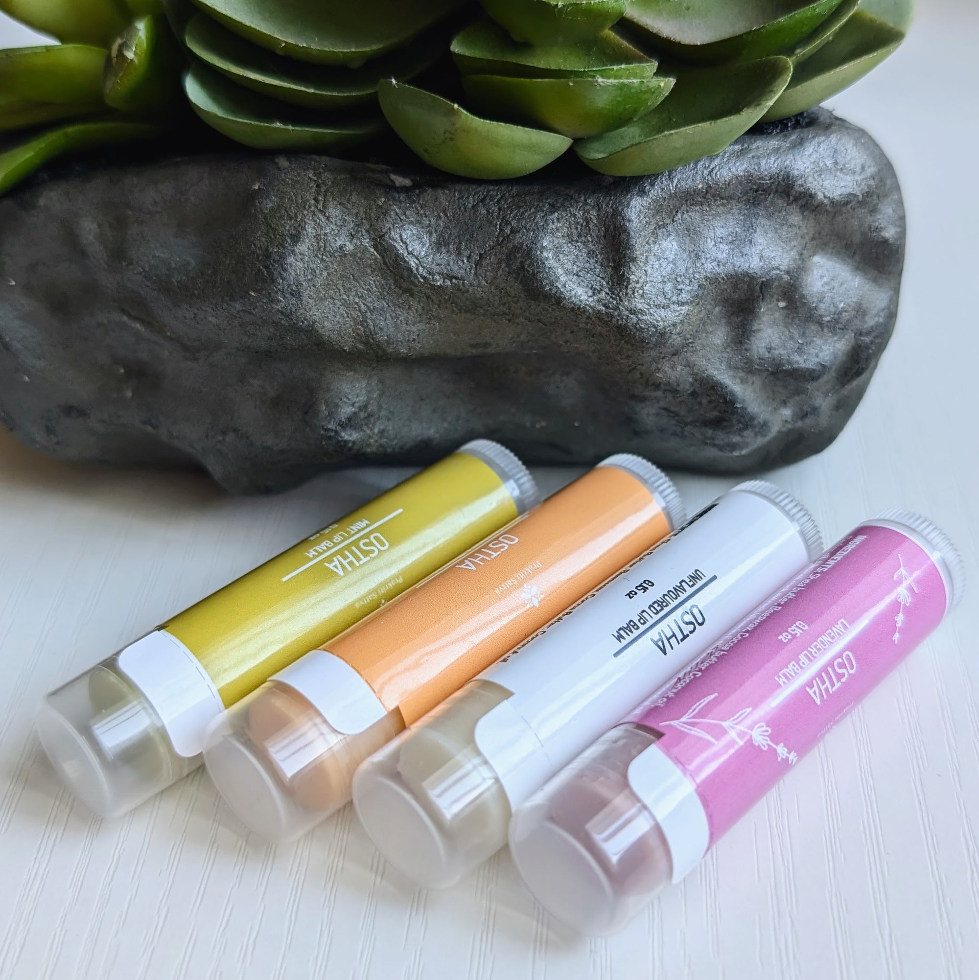 Ayurvedic natural lip balm with herbs infused for color. It is a tube of lip balm with a natural, earthy color. The label features Ayurvedic symbols and herbs, indicating the natural ingredients used.