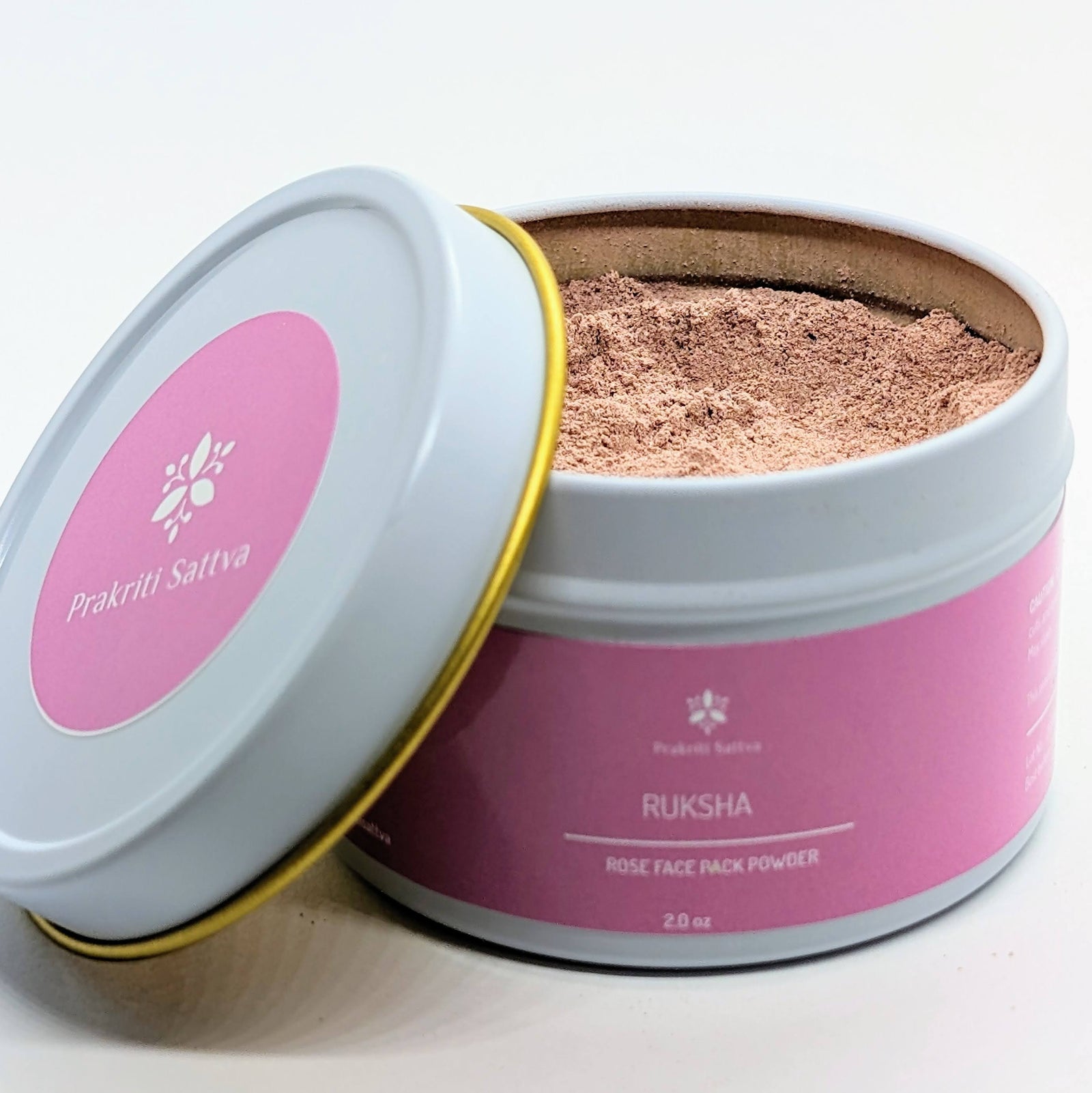 Ayurvedic Natural Rose Face mask , rose face pack. A jar of pink-hued face pack powder, perfect for natural skin care. The label features Ayurvedic symbols and herbs, including rose, colloidal oatmeal, French pink clay, hibiscus petals, licorice root, coconut milk, aloe vera, and essential oils, indicating the natural ingredients used.